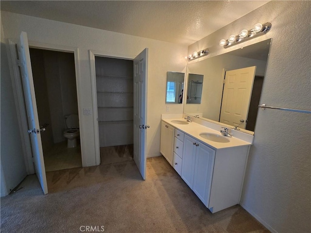 37515 Ruby Red Ln, Palmdale, CA 93551 - bathroom with double vanity, toilet, carpet flooring, a textured ceiling, and a textured wall