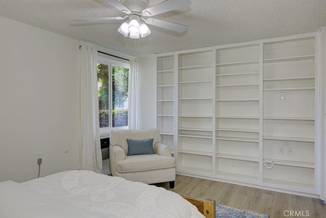 bedroom featuring ceiling fan, wood-type flooring, and a textured ceiling