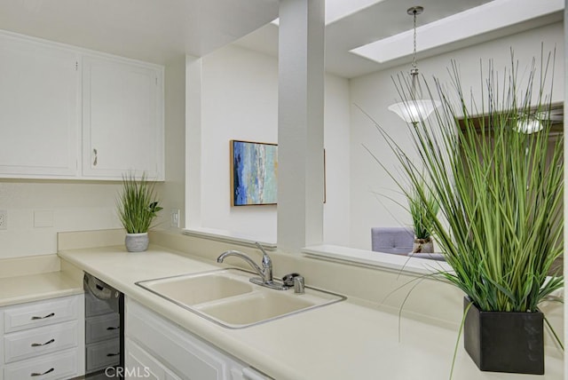 kitchen featuring white cabinets, decorative light fixtures, dishwasher, and sink