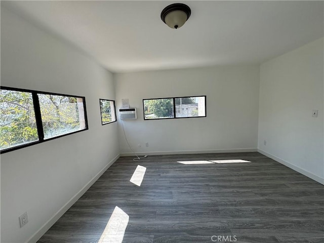 spare room featuring plenty of natural light and dark hardwood / wood-style flooring