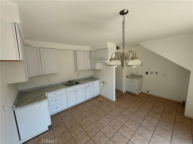 kitchen with white cabinetry, sink, a chandelier, pendant lighting, and light tile patterned flooring