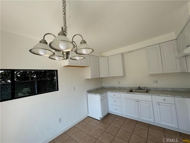 kitchen with white cabinets, pendant lighting, light tile patterned floors, and sink