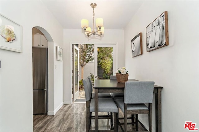 dining area with dark hardwood / wood-style floors and a chandelier