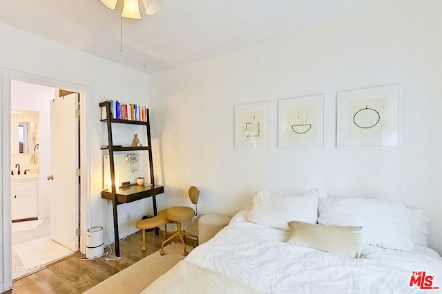 bedroom with hardwood / wood-style flooring, ensuite bathroom, and ceiling fan