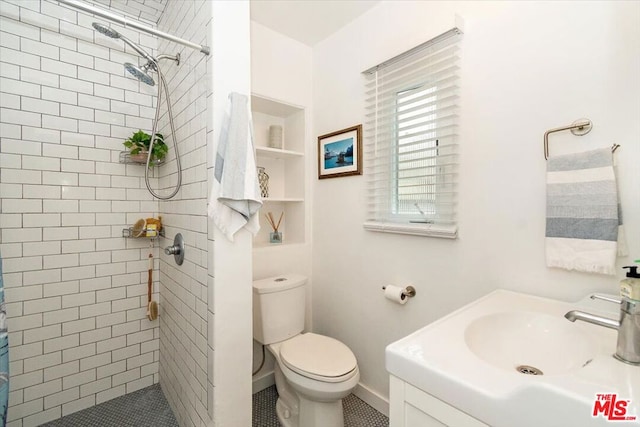 bathroom with tile patterned floors, toilet, vanity, and walk in shower