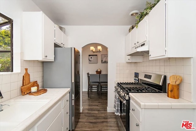 kitchen featuring dark wood-type flooring, sink, appliances with stainless steel finishes, tasteful backsplash, and white cabinetry