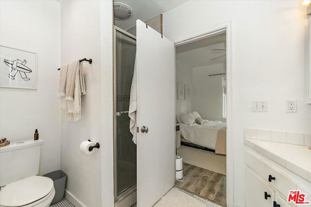 bathroom with vanity, hardwood / wood-style flooring, toilet, and walk in shower