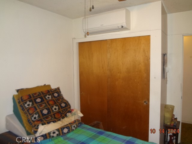 bedroom with a closet and a wall mounted air conditioner