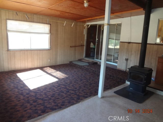 interior space with wood walls and a wood stove