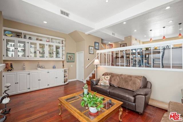 living room featuring beamed ceiling and dark hardwood / wood-style floors