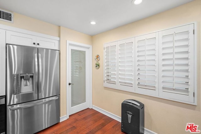 kitchen with stainless steel fridge, dark hardwood / wood-style flooring, and white cabinets