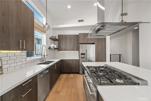 kitchen with hanging light fixtures, appliances with stainless steel finishes, plenty of natural light, light hardwood / wood-style floors, and sink