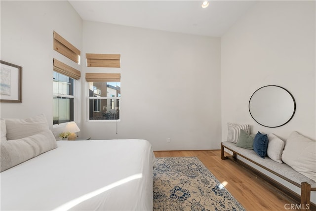 bedroom with light hardwood / wood-style floors and vaulted ceiling