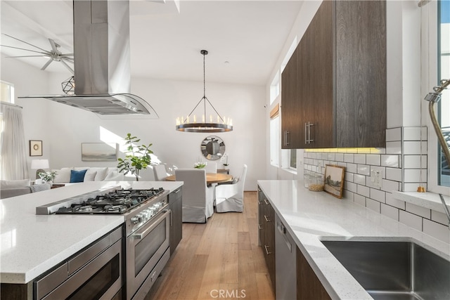 kitchen featuring island exhaust hood, light wood-type flooring, appliances with stainless steel finishes, and plenty of natural light