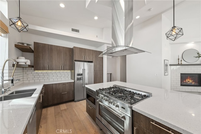 kitchen with pendant lighting, light hardwood / wood-style floors, high end appliances, and island range hood