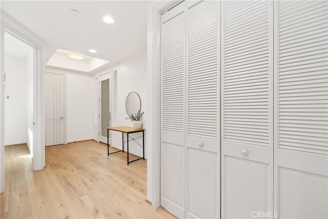 corridor featuring light hardwood / wood-style flooring and a raised ceiling