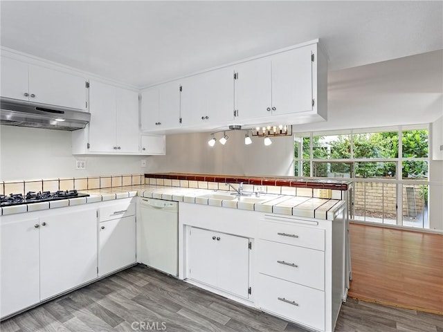 kitchen featuring hardwood / wood-style floors, tile countertops, white dishwasher, white cabinets, and kitchen peninsula