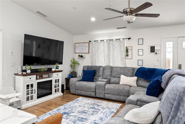 living room featuring ceiling fan, vaulted ceiling, and hardwood / wood-style flooring