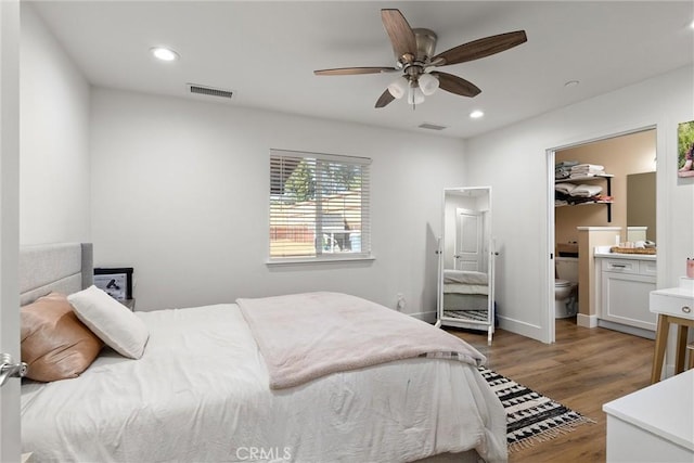 bedroom with ceiling fan, dark hardwood / wood-style flooring, and ensuite bathroom