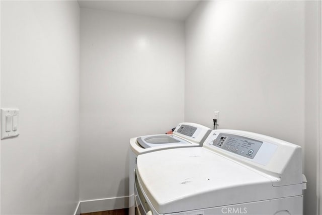 clothes washing area featuring independent washer and dryer and wood-type flooring