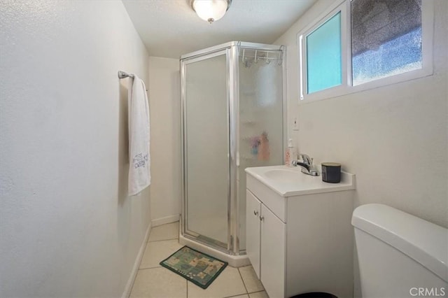 bathroom with tile patterned flooring, vanity, toilet, and a shower with shower door