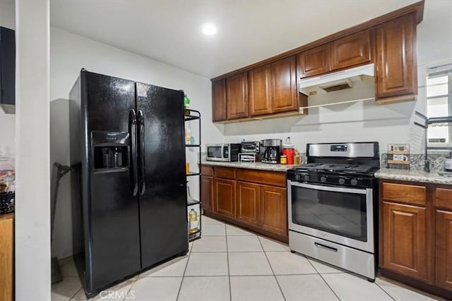 kitchen with light stone counters, stainless steel appliances, and light tile patterned floors