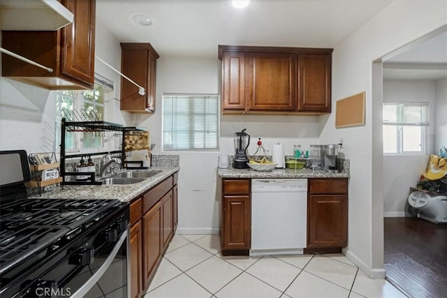 kitchen with sink, gas stove, light stone counters, dishwasher, and exhaust hood