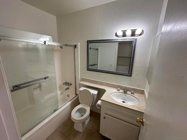 full bathroom featuring vanity, toilet, tile patterned floors, and combined bath / shower with glass door