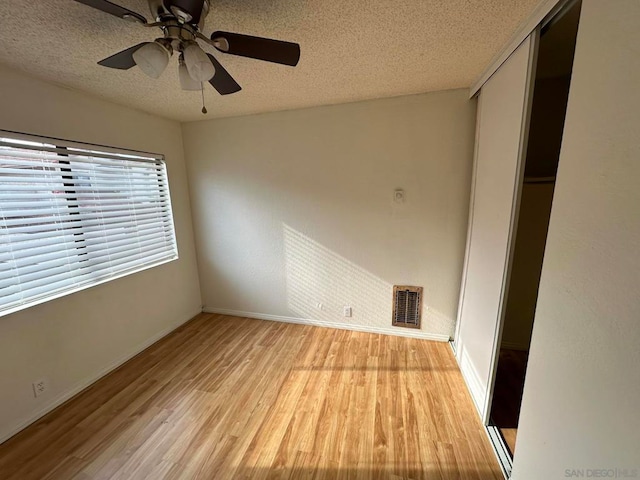 unfurnished bedroom with a textured ceiling, light hardwood / wood-style floors, and ceiling fan