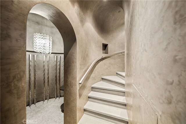 stairs with an inviting chandelier