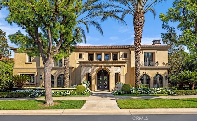 mediterranean / spanish-style house featuring french doors and a balcony