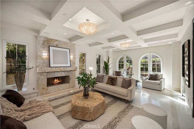 living room with beam ceiling, a high end fireplace, coffered ceiling, and an inviting chandelier