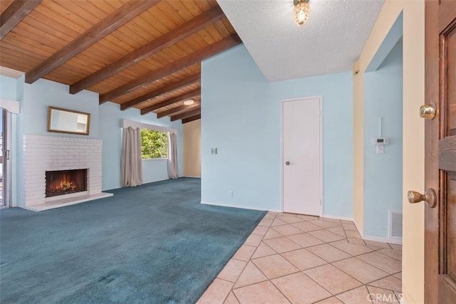 unfurnished living room featuring a brick fireplace, light tile patterned flooring, wood ceiling, and lofted ceiling with beams