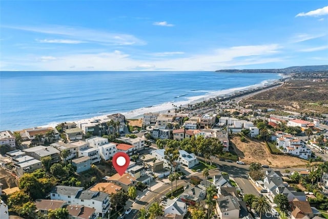 birds eye view of property featuring a beach view and a water view