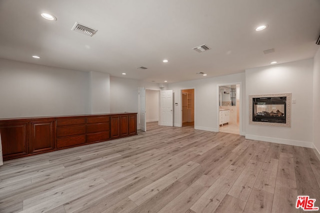 interior space with a multi sided fireplace and light hardwood / wood-style flooring