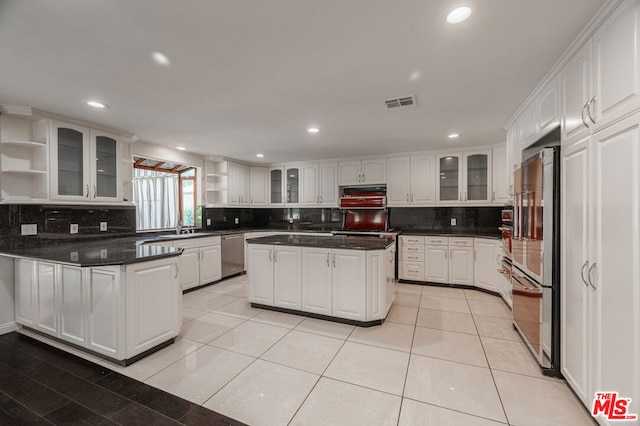 kitchen with white cabinets, appliances with stainless steel finishes, and tasteful backsplash