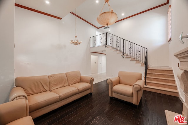 living room featuring hardwood / wood-style flooring, a notable chandelier, crown molding, and a high ceiling