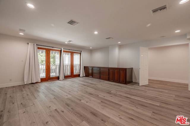 empty room with french doors and light hardwood / wood-style floors