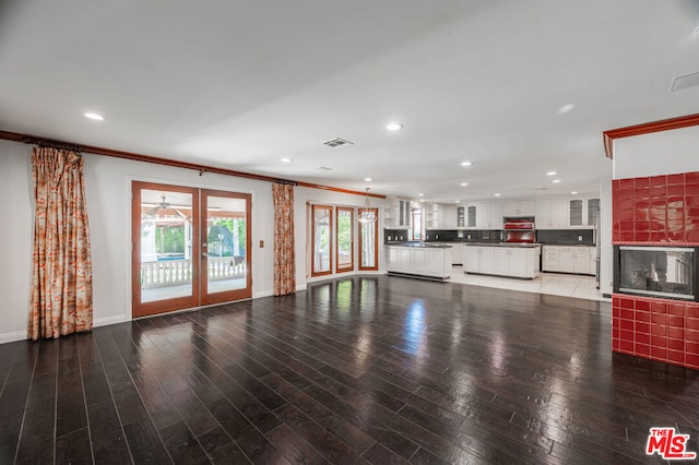 unfurnished living room with french doors, dark hardwood / wood-style flooring, and ornamental molding