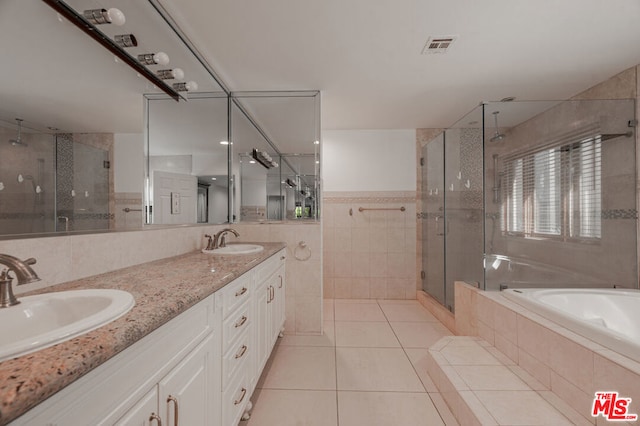 bathroom featuring tile patterned flooring, vanity, tile walls, and shower with separate bathtub