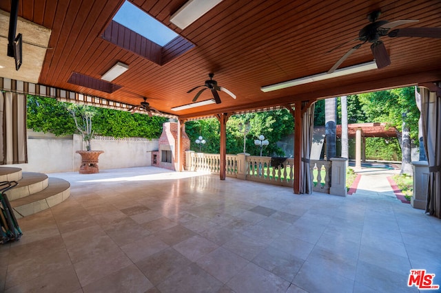 view of patio / terrace featuring ceiling fan and an outdoor fireplace