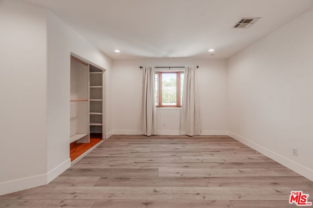 unfurnished room with light wood-type flooring