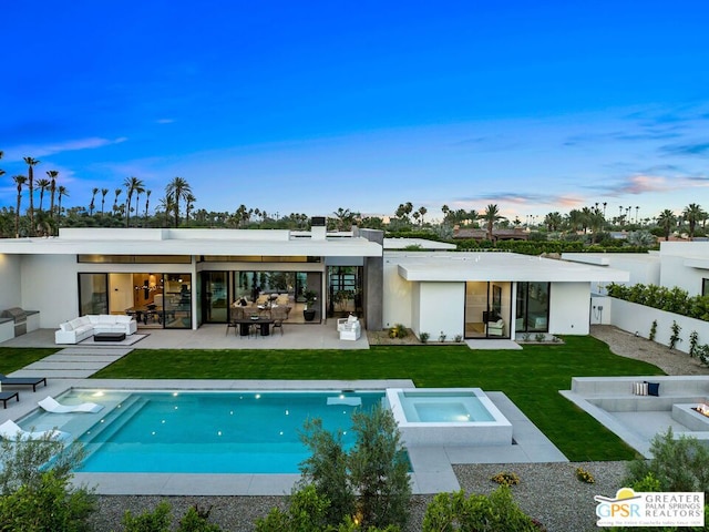 back house at dusk with a lawn, an outdoor living space, a patio, and a pool with hot tub