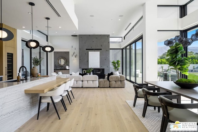 dining room featuring sink, a high ceiling, and light wood-type flooring