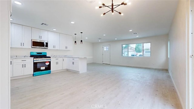 kitchen with pendant lighting, light countertops, open floor plan, white cabinetry, and stainless steel gas range