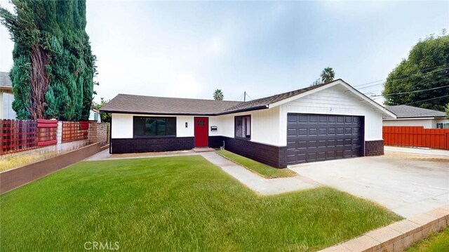 single story home with a garage and a front lawn