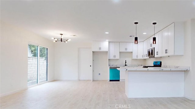 kitchen with light wood finished floors, white cabinetry, appliances with stainless steel finishes, and pendant lighting