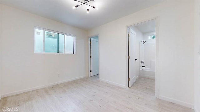 spare room with light wood finished floors and baseboards