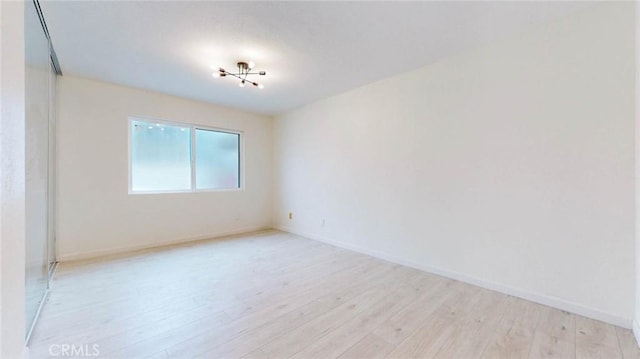 spare room with light wood finished floors and baseboards