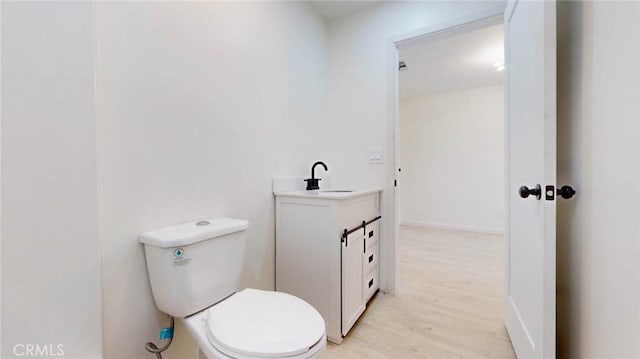 bathroom with vanity, toilet, and wood finished floors